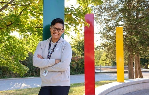 Mary Anne Afable smiling outdoors in front of colourful pillars.