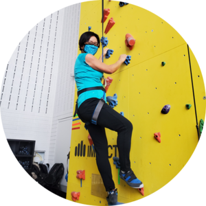 ​Dean Lili Liu trying out the new rock climbing wall on campus. 