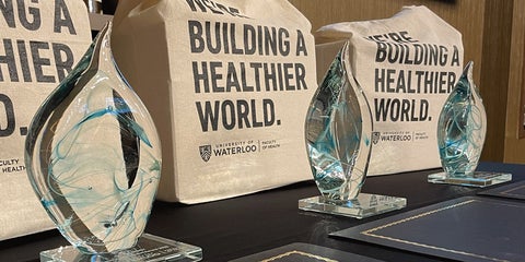 Row of alumni award crystal water shaped statues and building a healthier world gift bags.