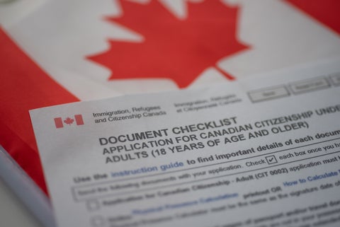 Citizenship form rests on Canadian flag.