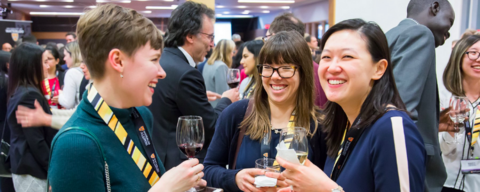 Alumni wearing name tags socialize at a cocktail event.