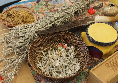 Dried sage, eagle feather and other Indigenous items on display.