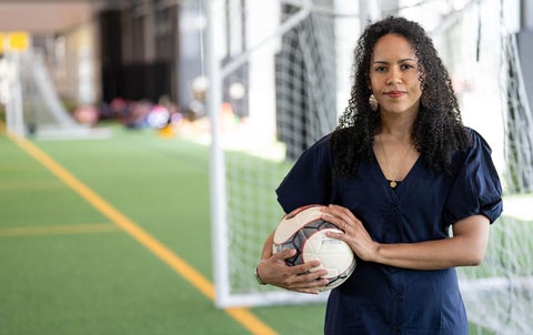 Dr. Kaleigh Pennock on soccer pitch holding ball.