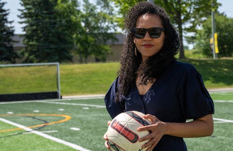 Dr. Kaleigh Pennock on outside pitch wearing sunglasses, holding ball.