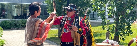 Dean Liu and Elder Henry holding up the Eagle Feather