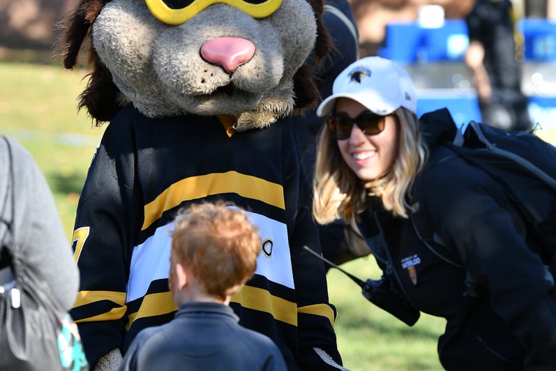 King Warrior, University of Waterloo mascot taking a photo with a child