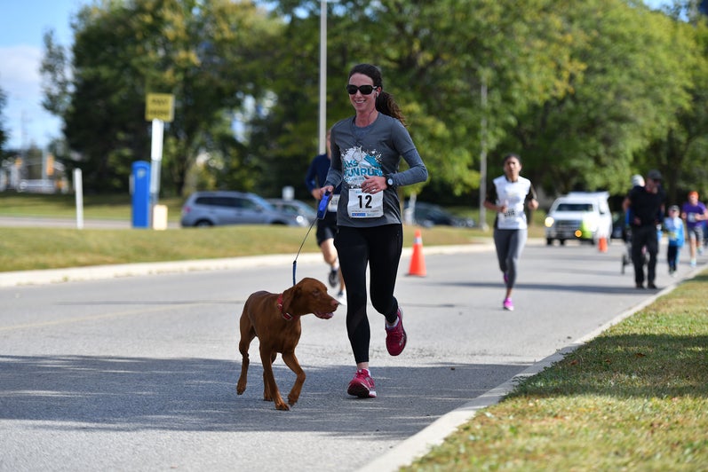Female Fun Run participant running with a dog