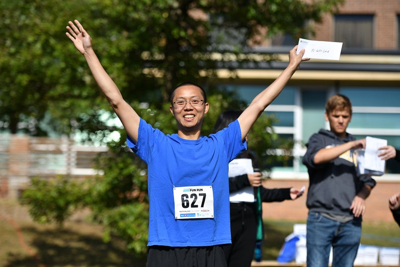 Fun Run prize winner smiling with arms up