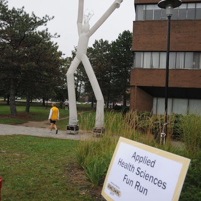 Inflatable floating balloon shaped as a person in front of Applied Health Sciences Building