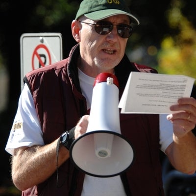 A man reading a paper out loud through a megaphone