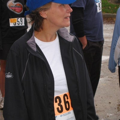 A female participant with a blue cap paying attention to the speaker
