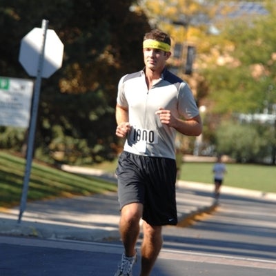 A man wearing a yellow sports headband running