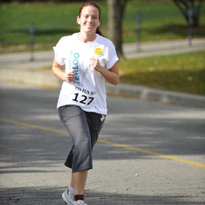 A female runner running while listening to music with her earphones