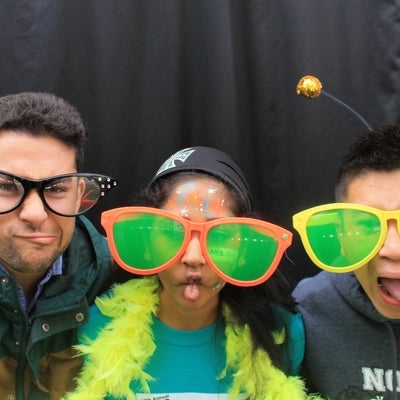 Three students wearing oversized glasses and making funny faces.