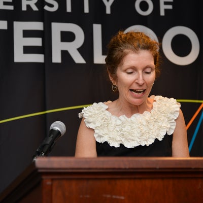A lady making a speech behind a podium.