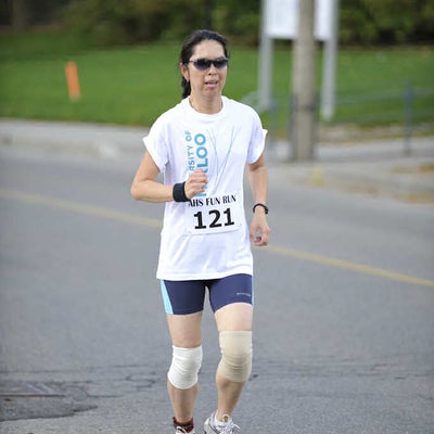 A female runner running with sunglasses on