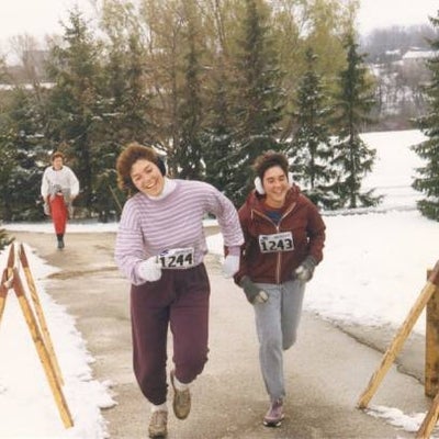 Two female participants reaching the finish line laughing. 