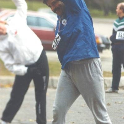 A male runner focused stretching with other participants