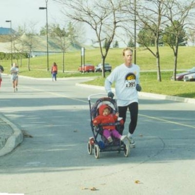 A man running the race with his baby in a baby stroller.