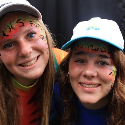Two girls with hats and face paintings.