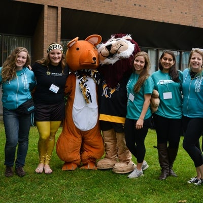 Seven students posing with two mascots.