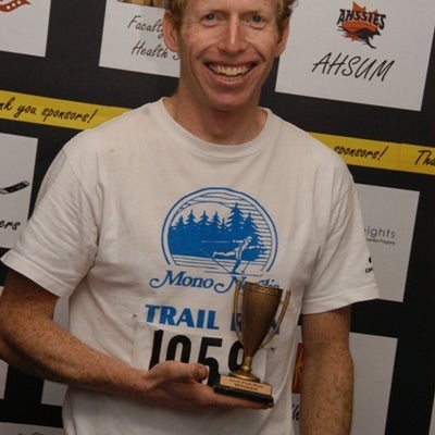 A man with a little trophy on his right hand