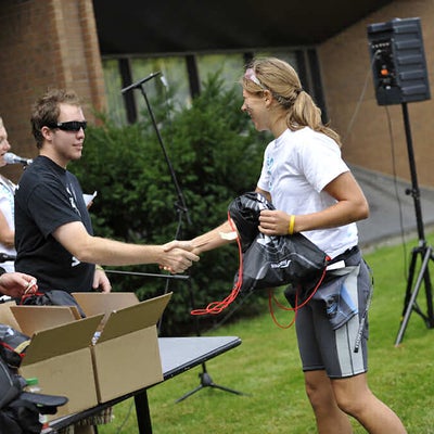 A female participant and a staff shaking hands