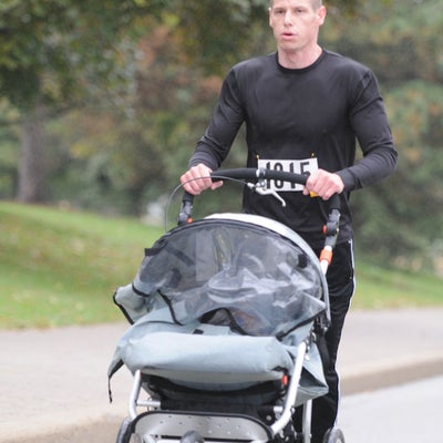 A man running with his baby in a baby stroller