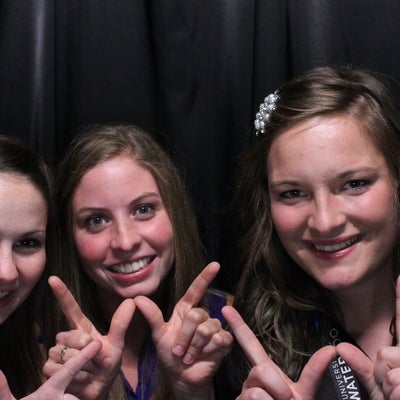 Three ladies posing for a photo while making a W with their hands.