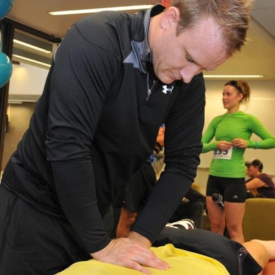 A staff member giving a massage to a runner