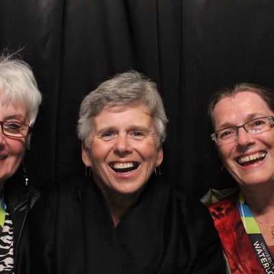 Three ladies smiling and posing for a photo.