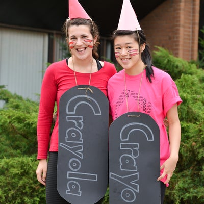 Two students dressed up as a red and pink Crayola crayons.