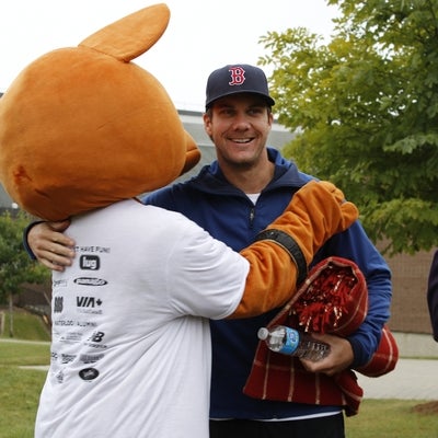 AHSSIE the mascot hugging a runner