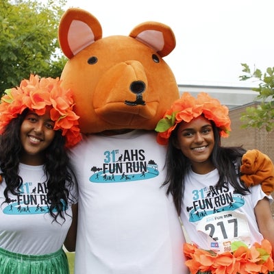 Two runners with AHSSIE the mascot