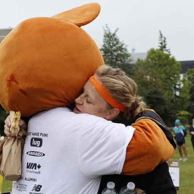 AHSSIE the mascot hugging a girl