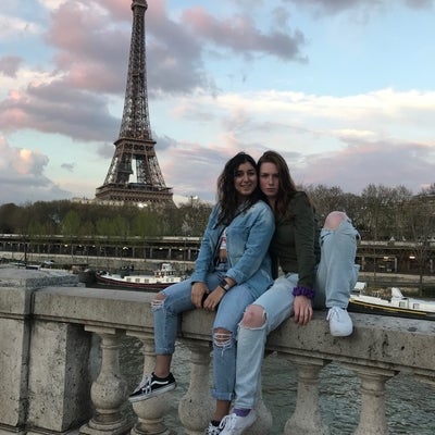 Aysun and friend sitting with Eiffel tower in the background.