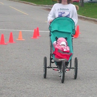 A woman running the race with her baby in a baby stroller.