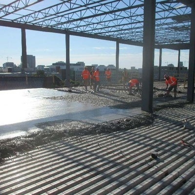 Partially poured concrete floor going over wire mesh.