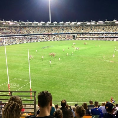 Stadium for australian football, filled with fans.