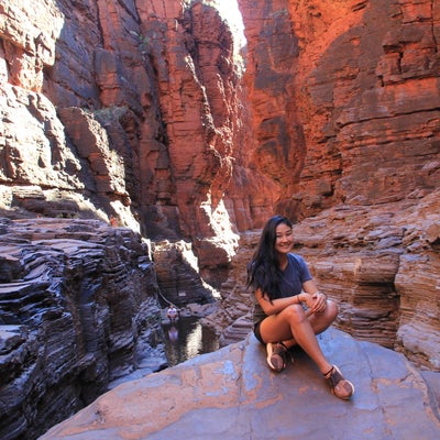 Cyanne seated at the base of a large gorge.