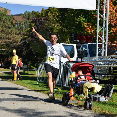 Participant pushing stroller passing the finish line