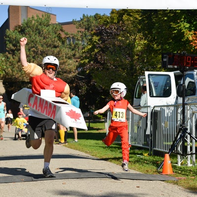 Particpants dressed in Canada gear passing the finish line