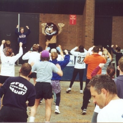Participants stretching with an instructor in the front and the lion mascot
