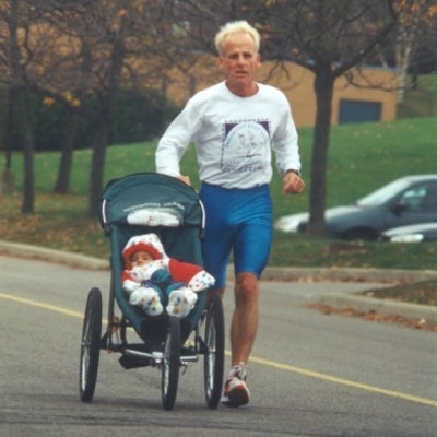 A man running with baby in a baby stroller