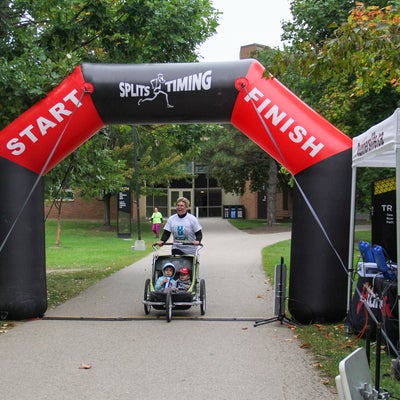 Faculty of health member Julie at finish line with stroller