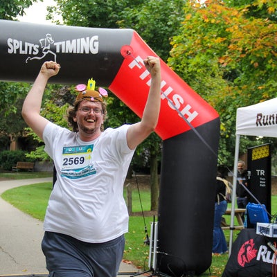 runner with mouse costume cheering at finish line