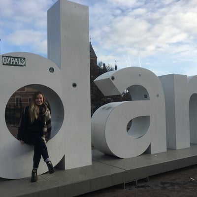 Tess sitting on the I am Amsterdam sign 