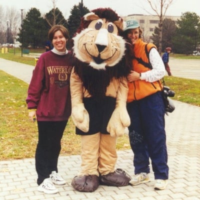 A lion mascot of the Fun Run race standing in the middle with two females