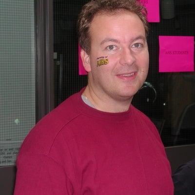 A man with a sticker tatoo written "Faculty of AHS" on his face