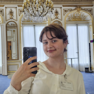 Selfie taken inside the OECD building in a meeting room, with my visitor badge